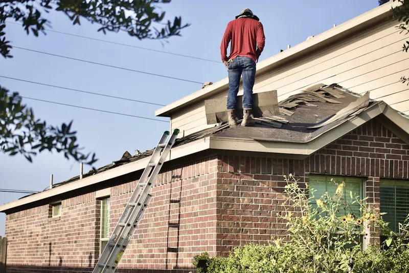 Professional roofer working on a residential roof in Attawaugan